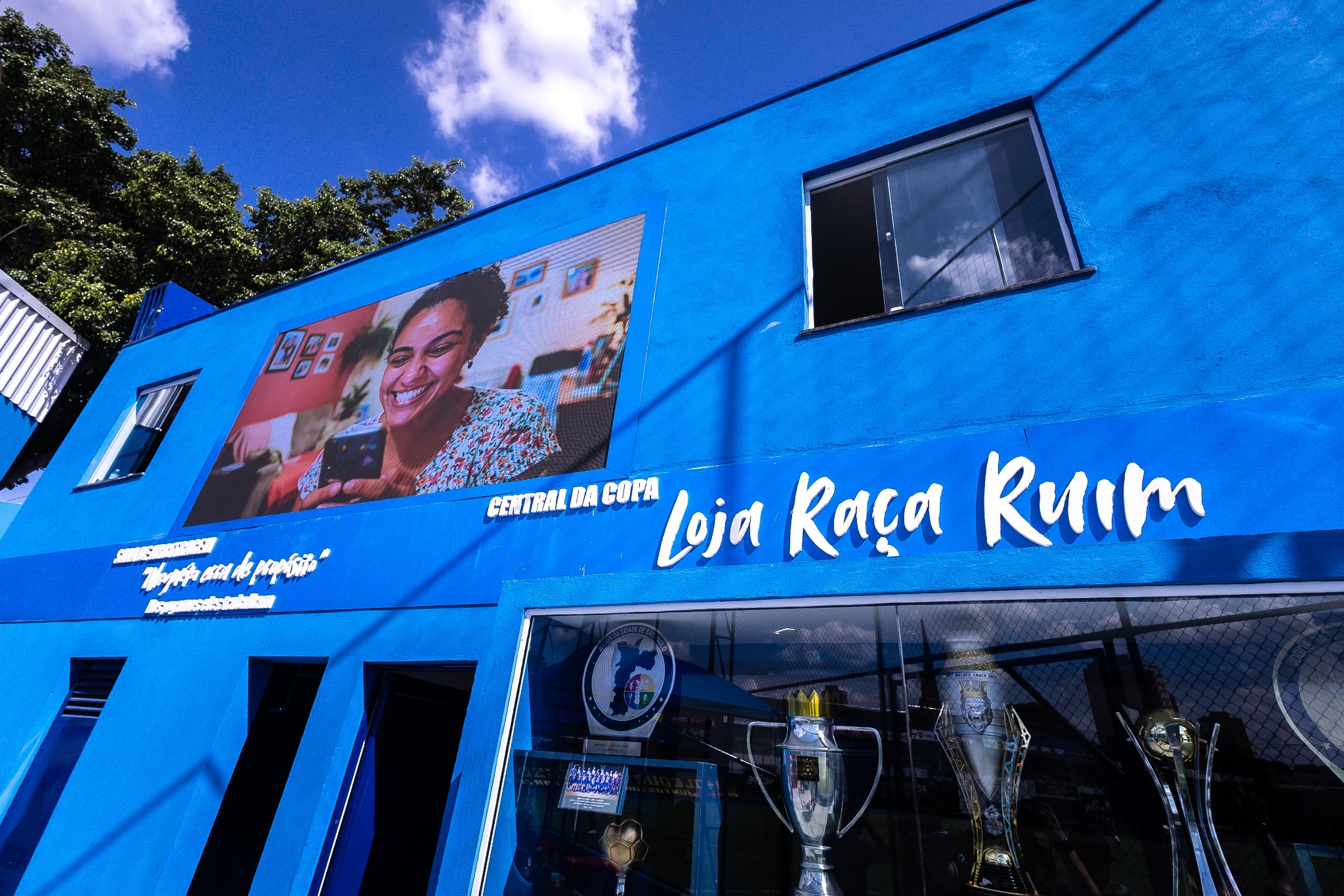 Fachada azul identificada como Central da Copa e Loja Raça Ruim