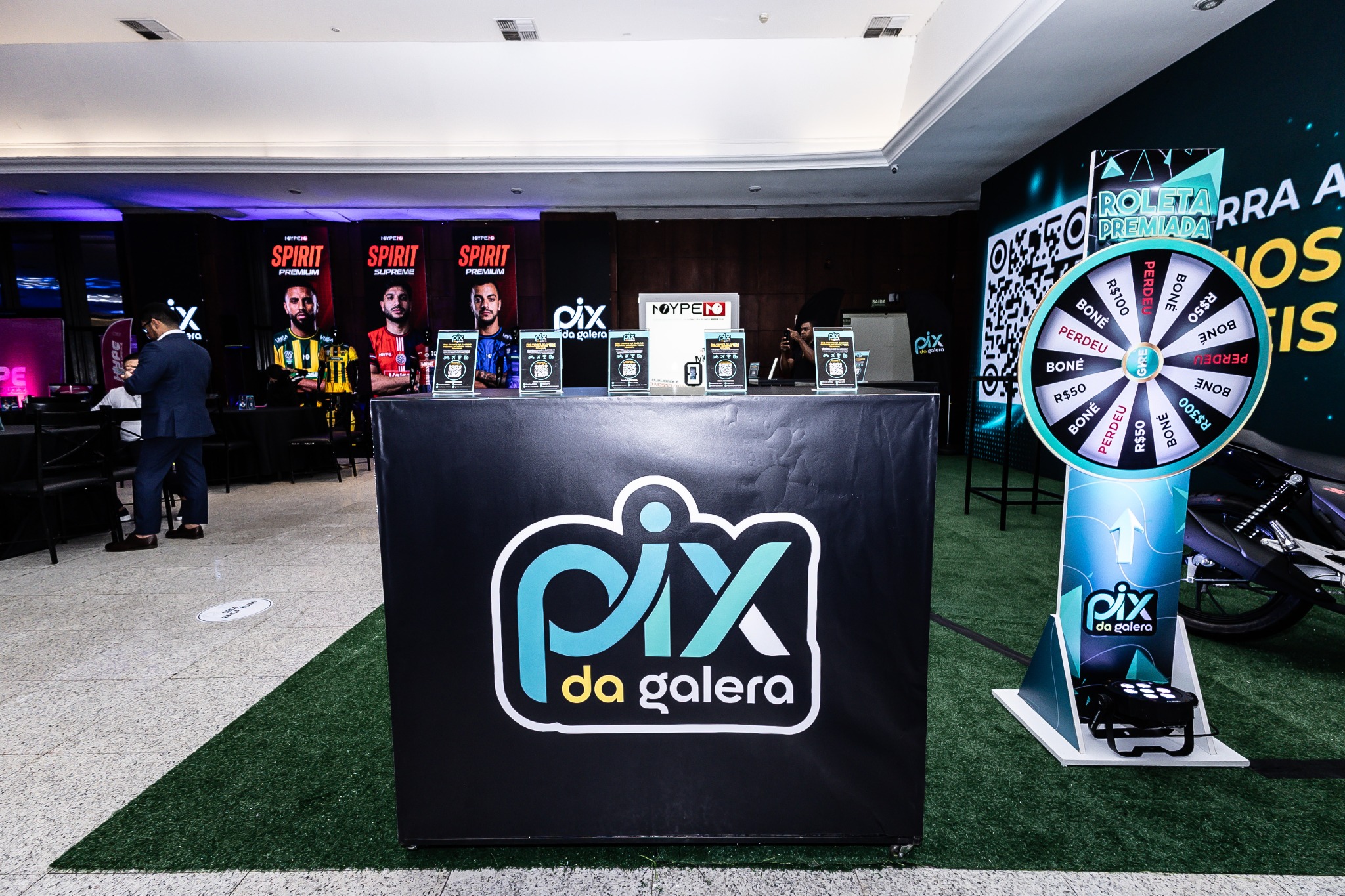 Balcão da marca e roleta instalados no espaço do evento.