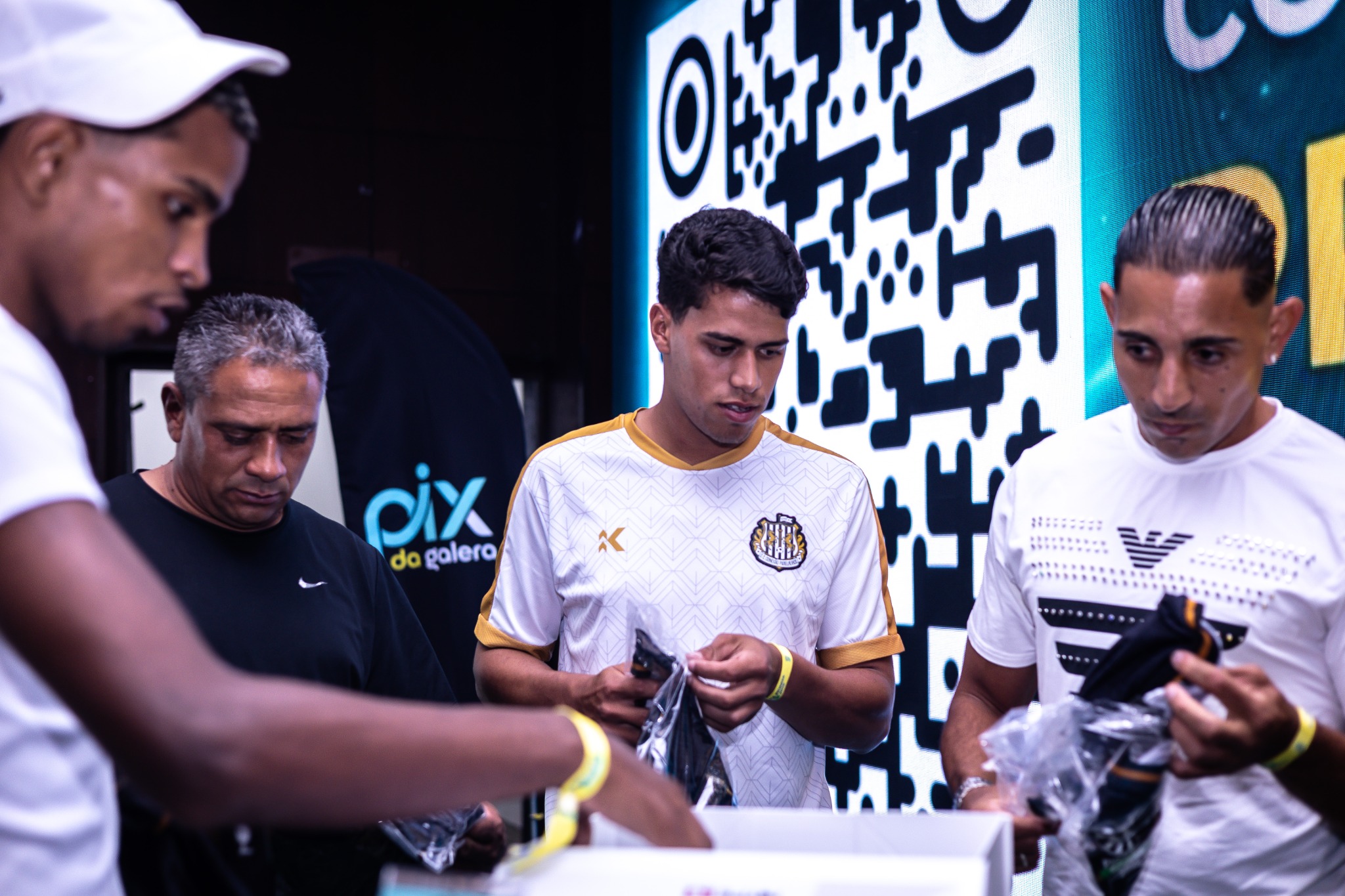Participantes reunidos junto ao painel e ao QR code do espaço.