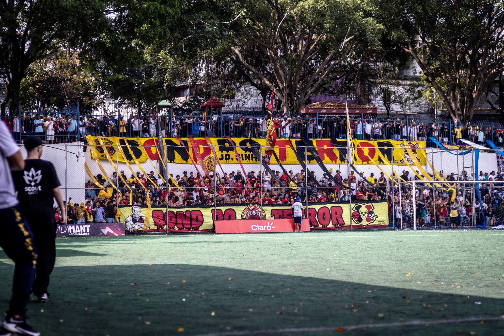 Torcida reunida atrás do gol com bandeiras e faixas durante uma partida