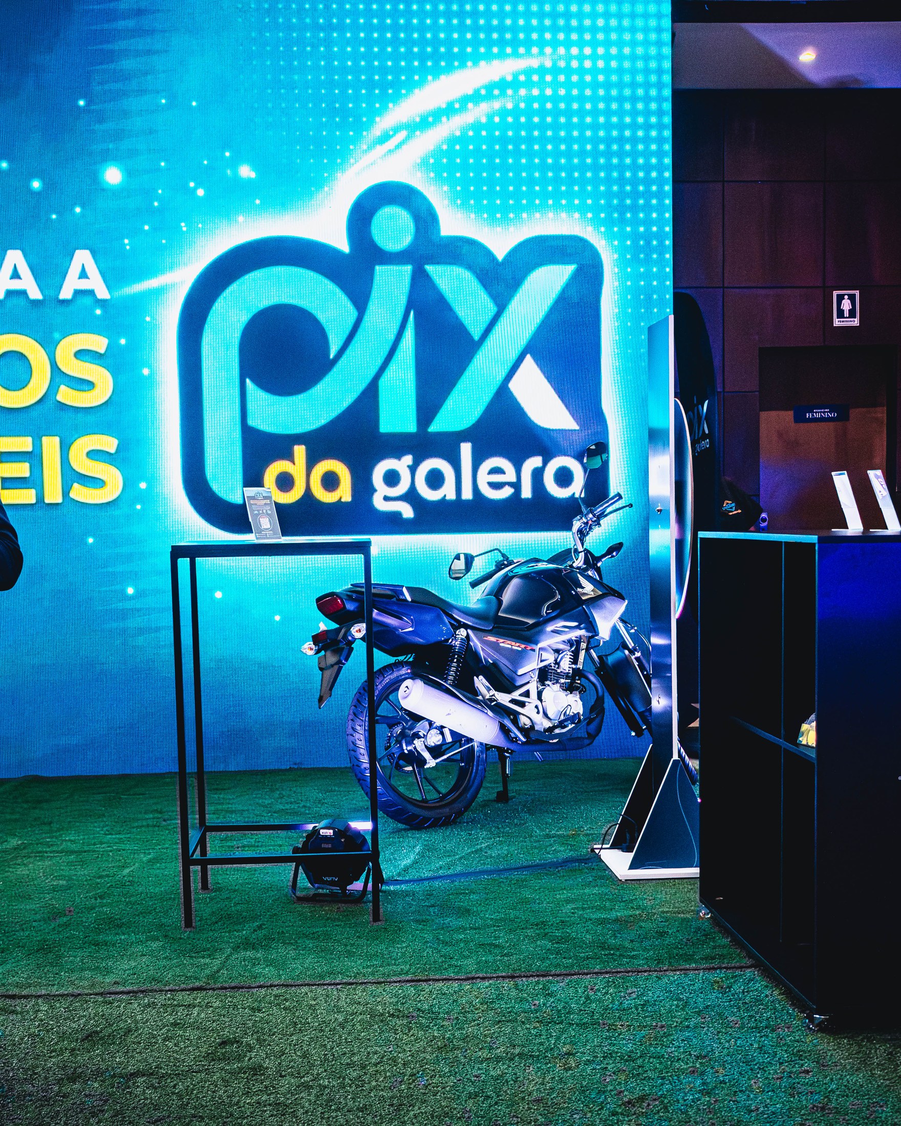 Apresentador com camisa PIX DA GALERA durante atividade no palco.