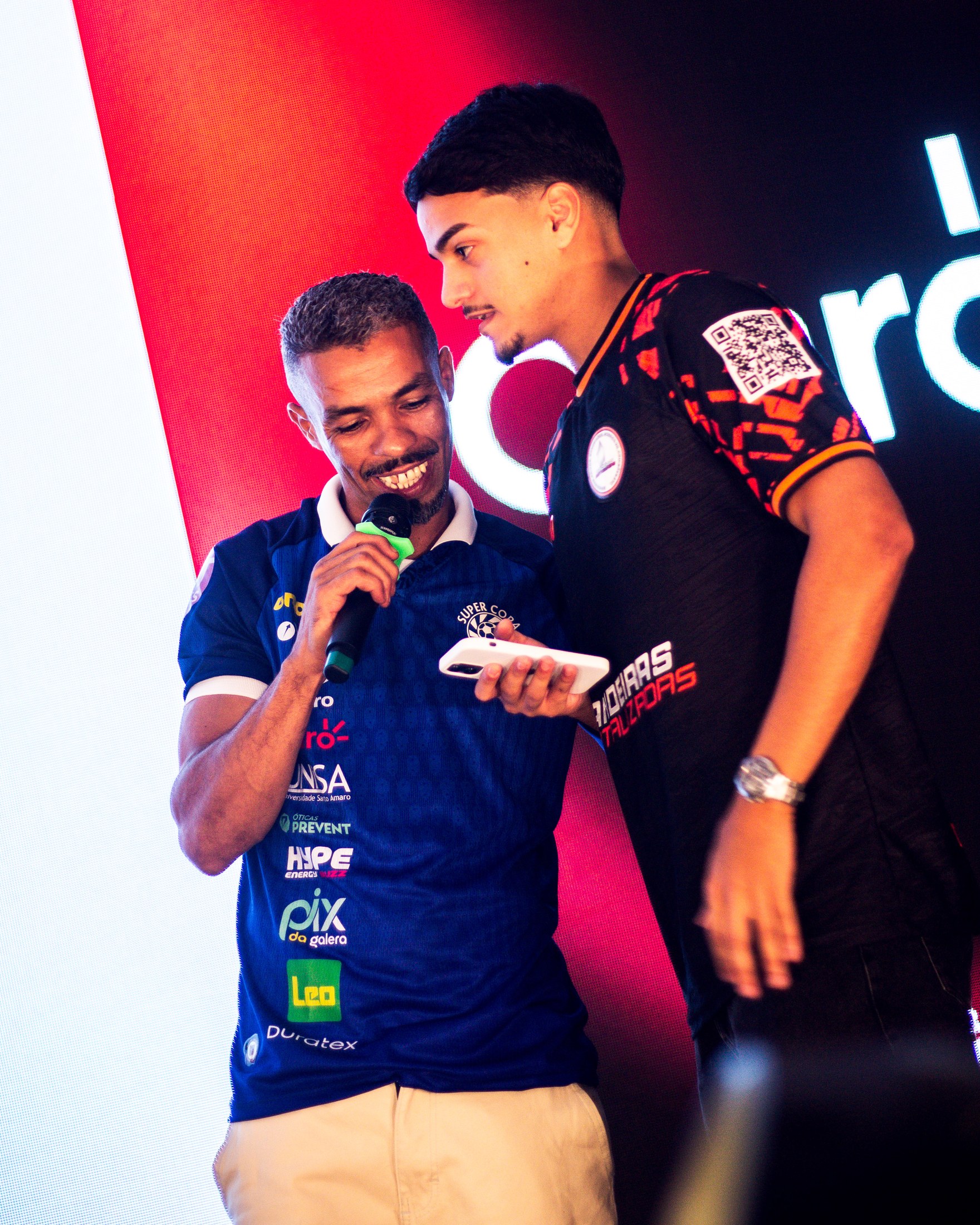 Participantes no palco ao lado de sinalização da PIX DA GALERA.