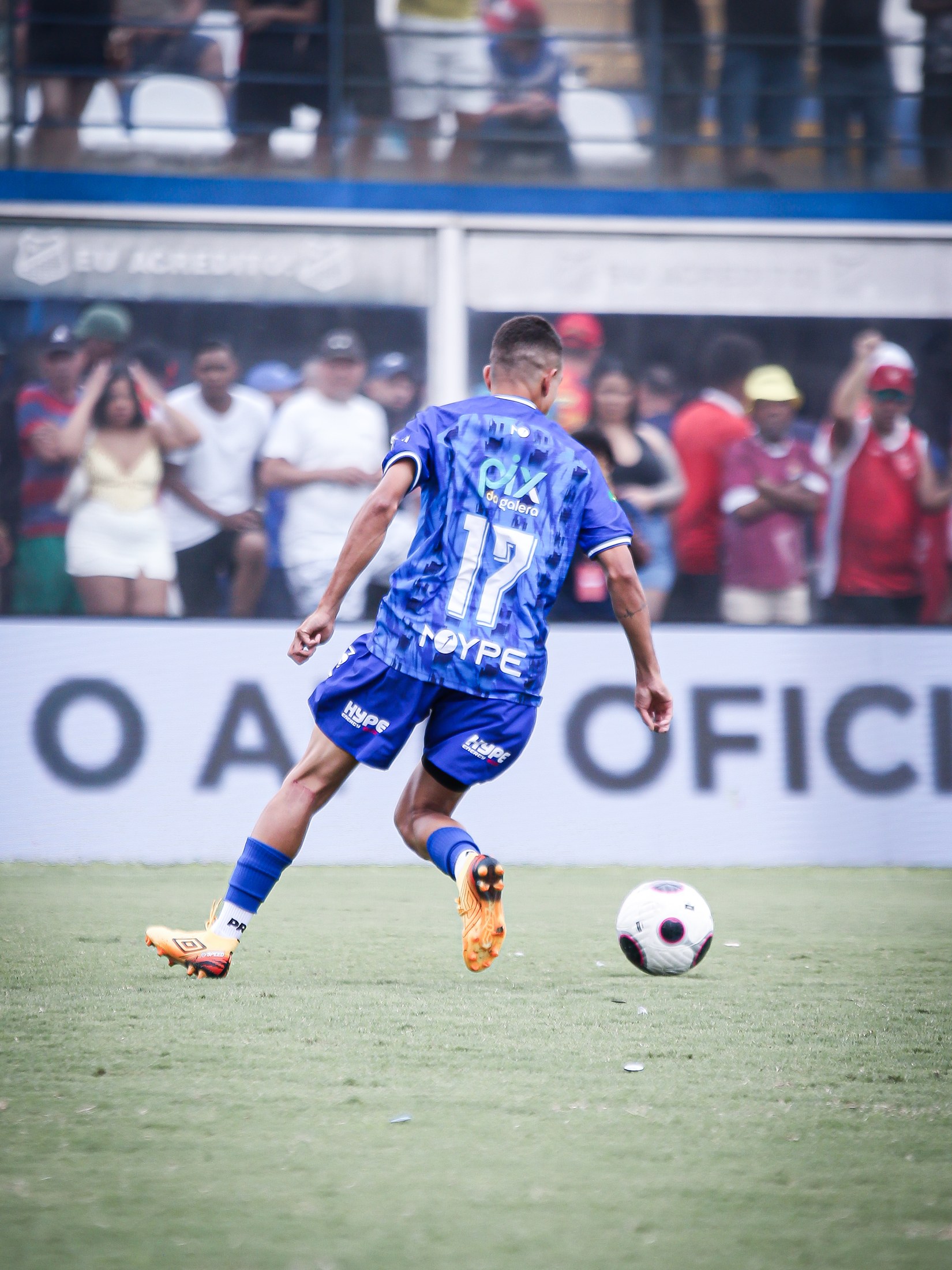 Atleta em movimento no gramado; o logo PIX DA GALERA aparece no uniforme azul.