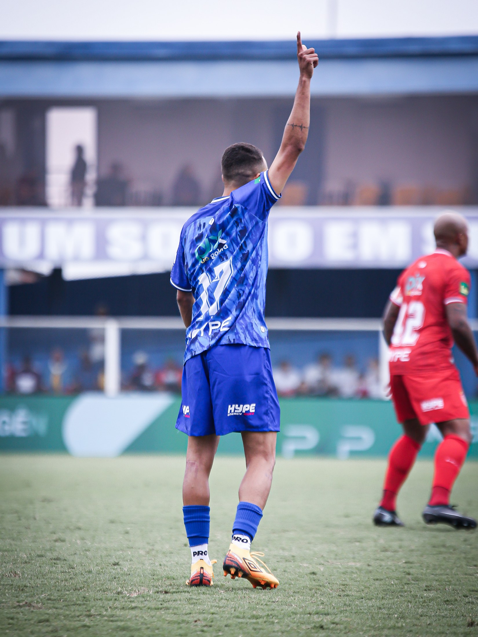 Jogador visto de costas após o lance, com PIX DA GALERA visível no uniforme azul.
