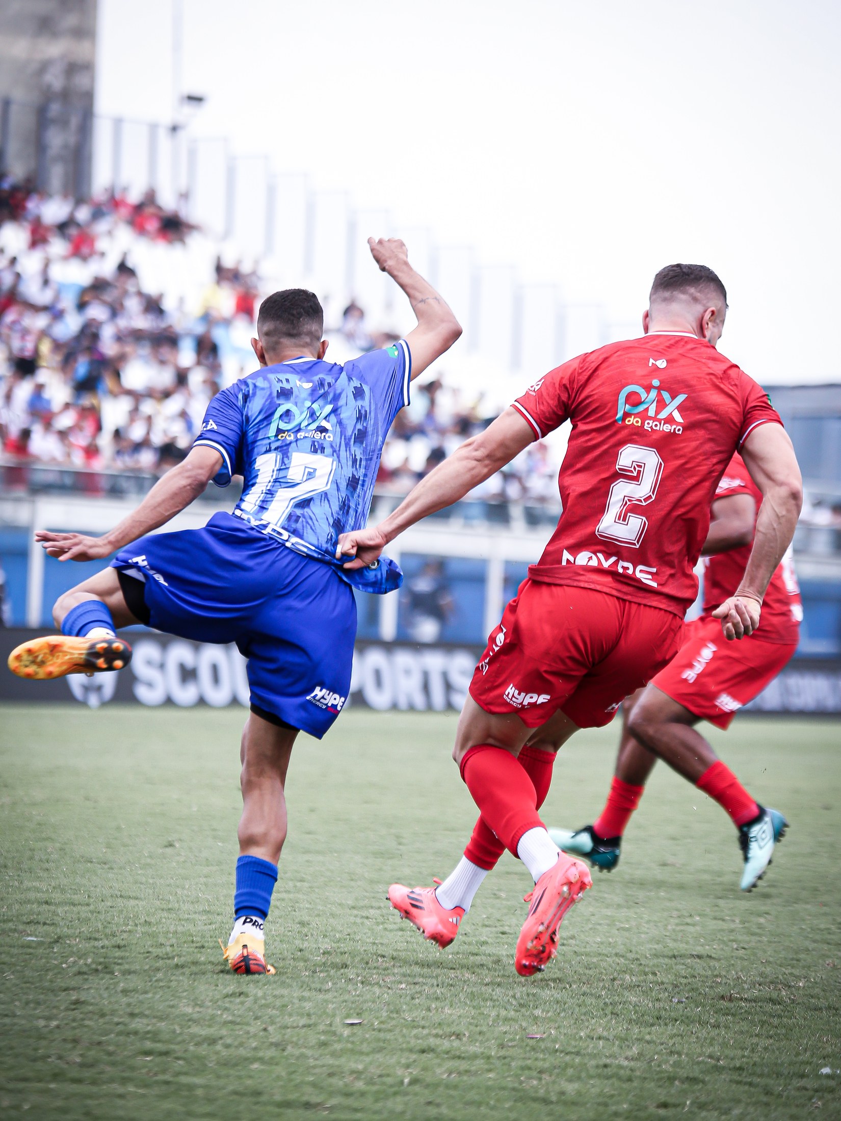 Atletas das equipes azul e vermelha disputam a jogada; o logo PIX DA GALERA aparece nos dois uniformes.