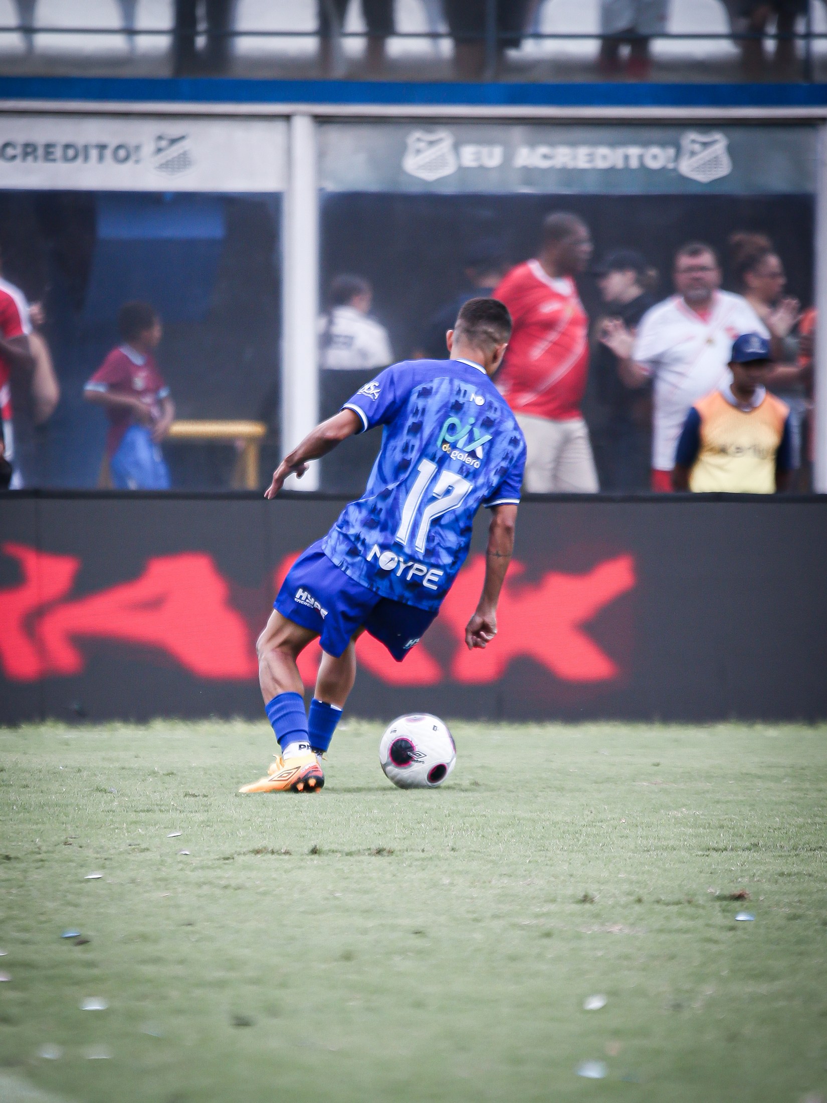 Atleta conduz a bola com PIX DA GALERA legível nas costas da camisa.