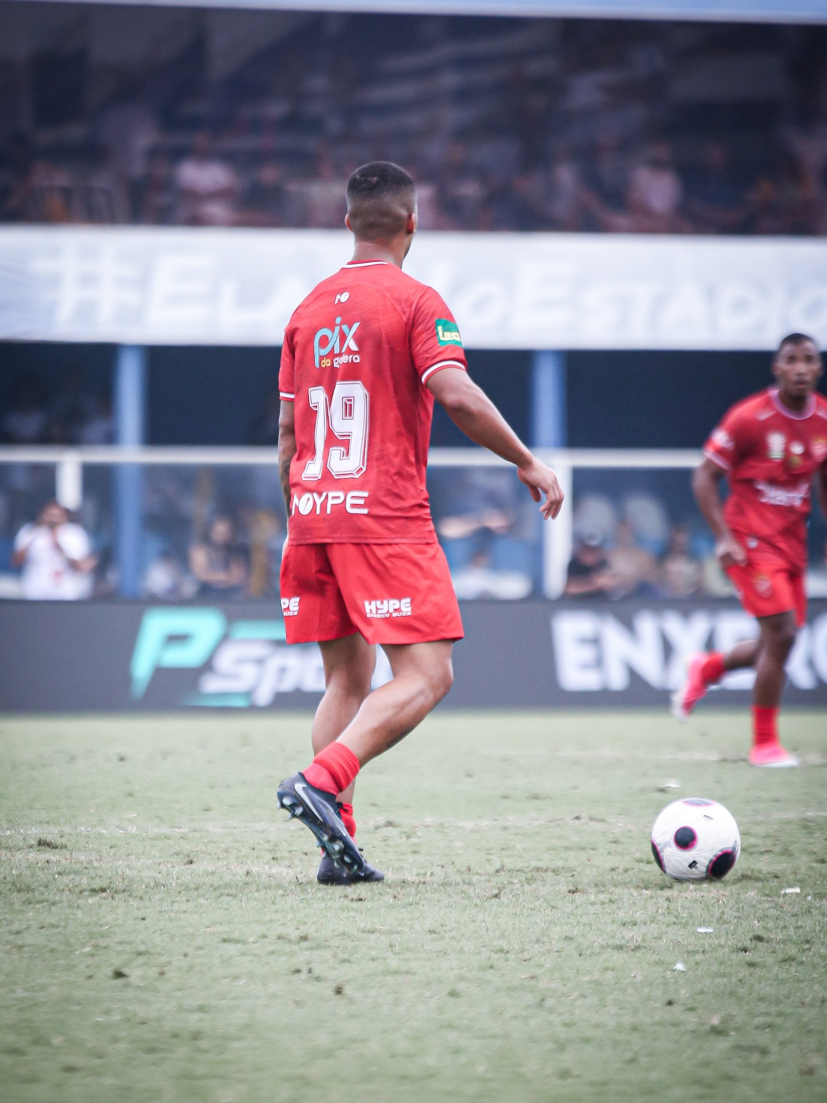 Atleta corre em campo com o logo PIX DA GALERA legível nas costas.