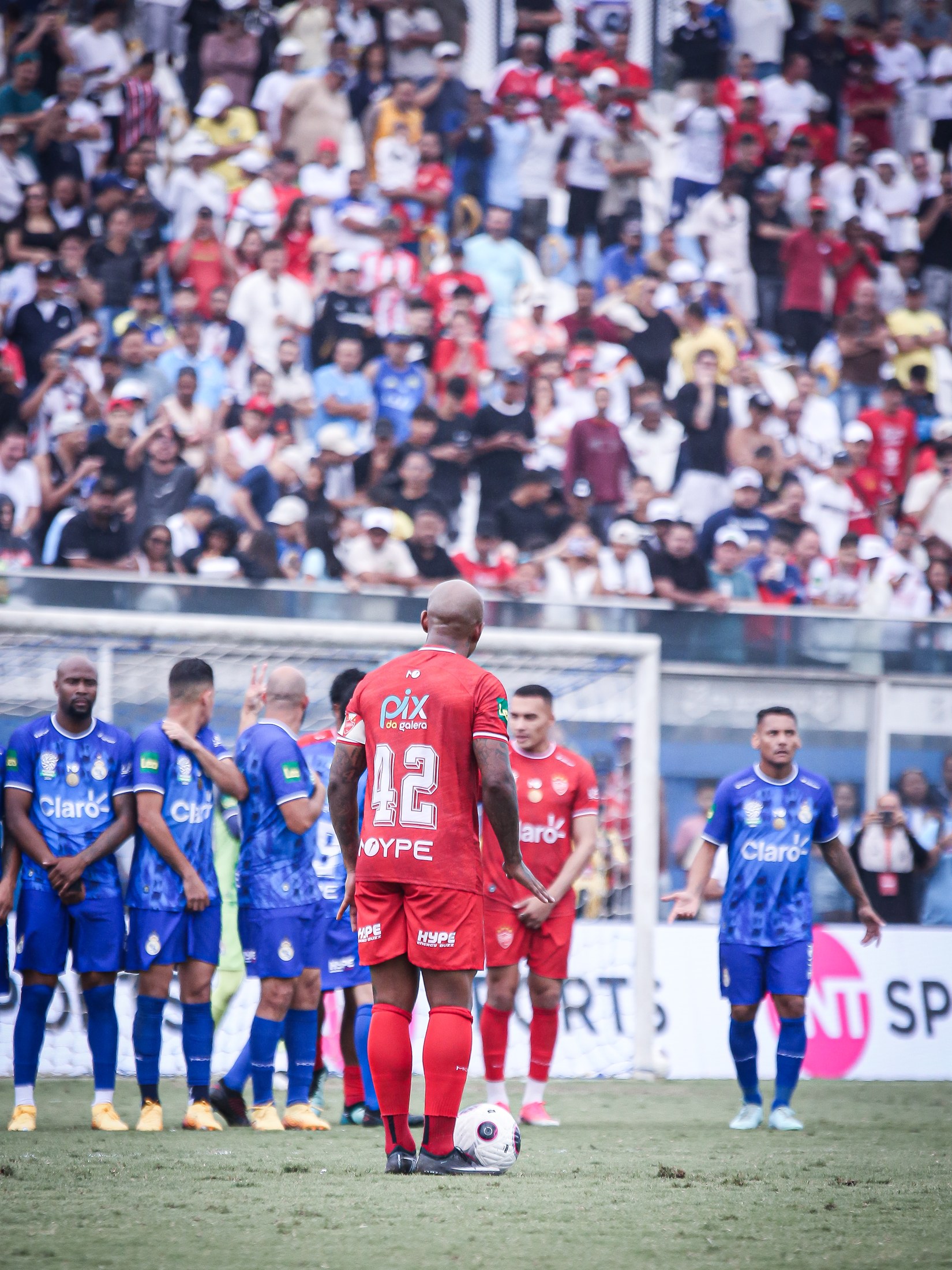 Atleta da equipe vermelha aguarda o lance com PIX DA GALERA visível na camisa.
