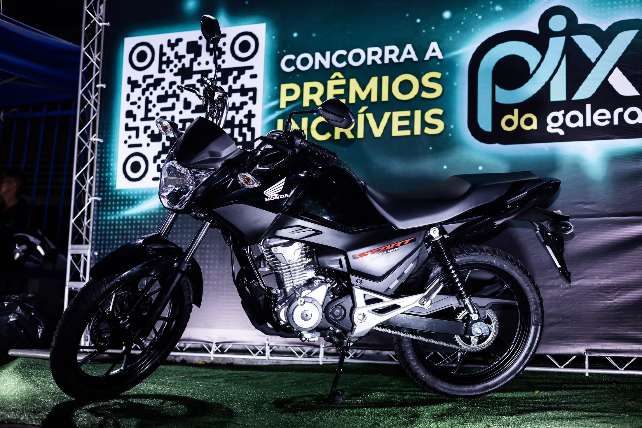 Motocicleta em exposição diante do painel PIX DA GALERA durante a abertura da SCP 2026.