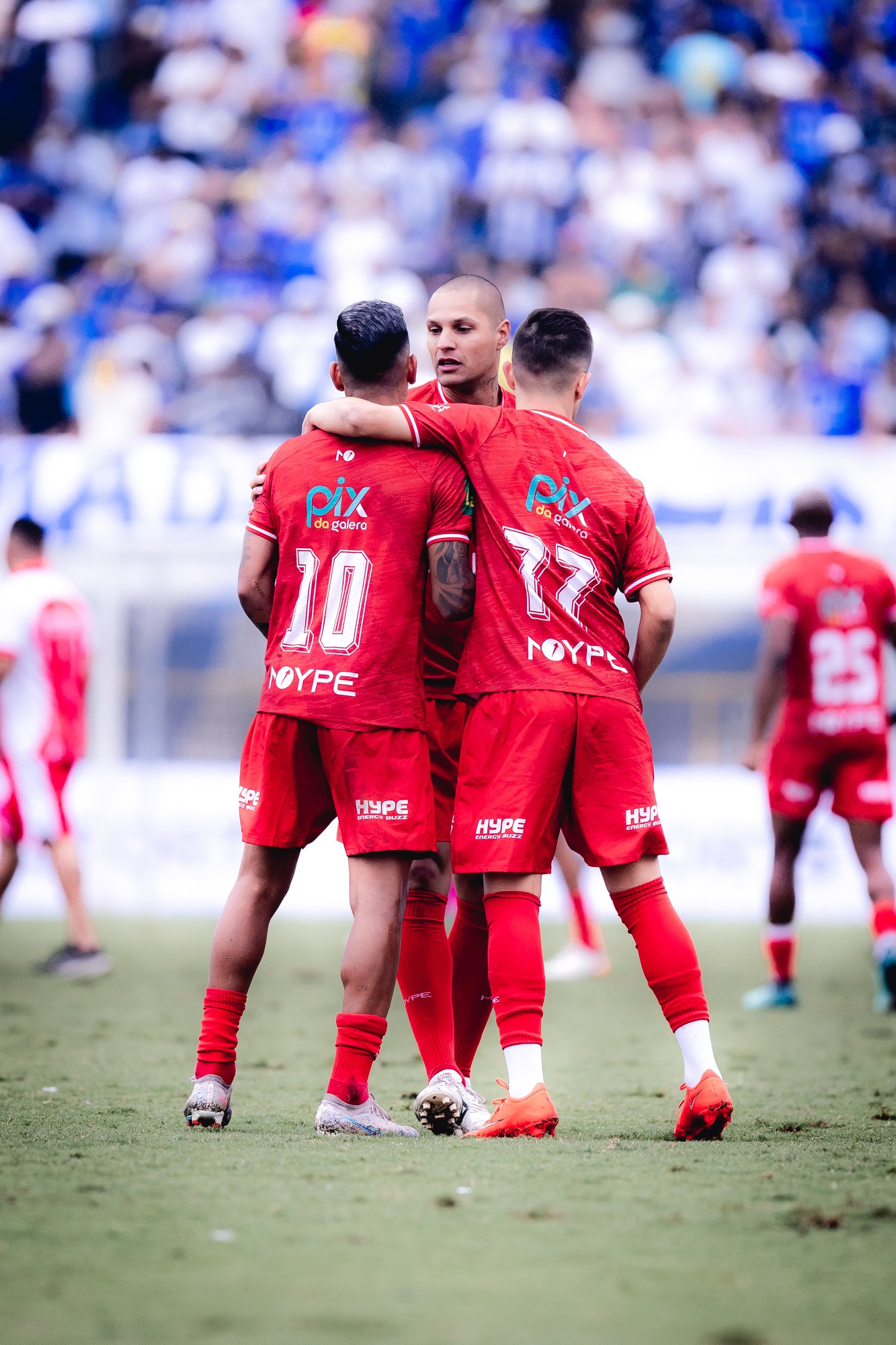 Jogadores se juntam durante a partida, com a marca PIX DA GALERA visível nos uniformes.