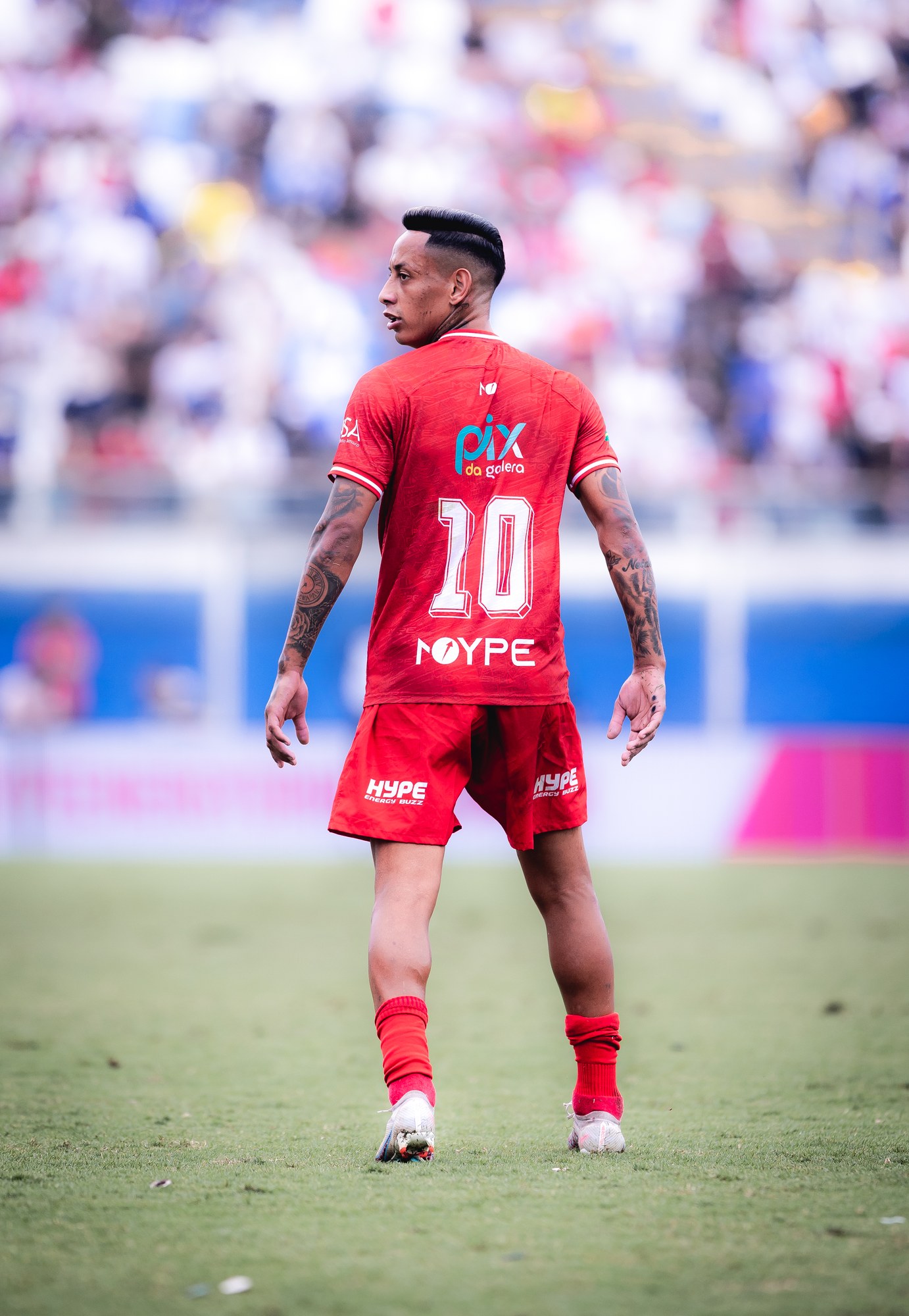 Jogador observa a partida de costas; o logotipo aparece acima do número 10.