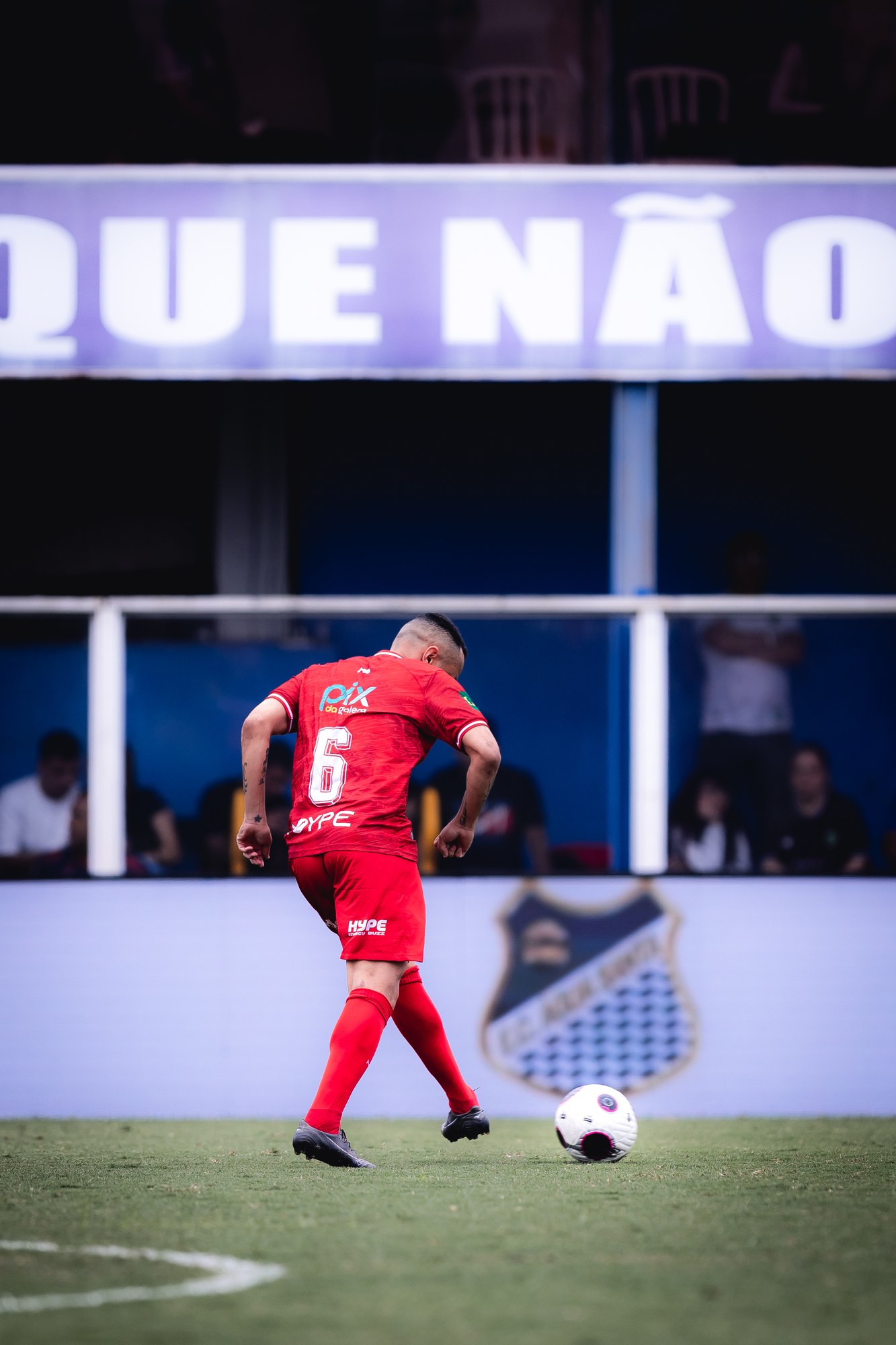 Jogador conduz a bola com a marca PIX DA GALERA visível na parte de trás da camisa.