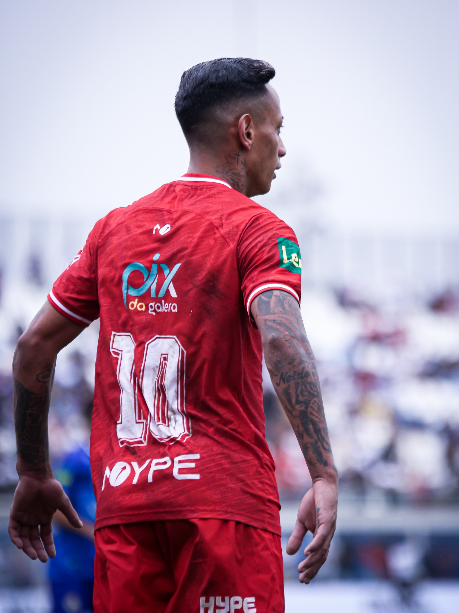 Atleta visto de costas com a marca PIX DA GALERA visível no uniforme vermelho