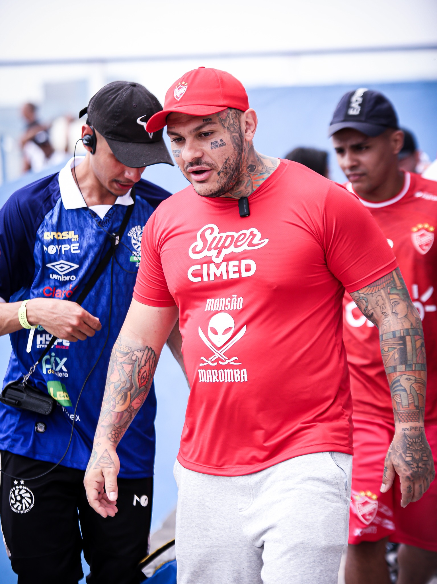Profissional em camisa azul com a marca PIX DA GALERA visível ao lado de integrante da equipe